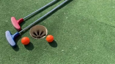 Mini golf sopaları ve farklı renkte toplar suni çimlerin üzerine konmuş. Yüksek kalite fotoğraf