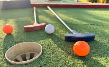 Sentetik çimlerin üzerinde golf topları olan renkli golf sopaları. Yüksek kalite fotoğraf