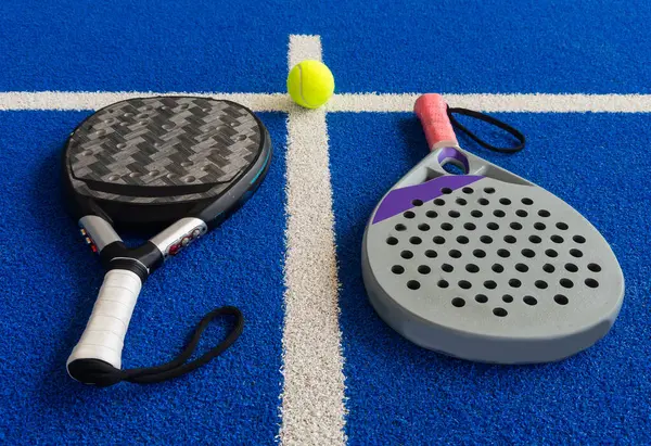 stock image Paddle tennis: Paddel racket and ball in front of an outdoor court. High quality photo