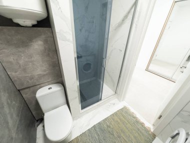 Cam duş kabini olan tuvalet, kiralık tatil dairesinde beyaz porselen lavabo. Yüksek kalite fotoğraf