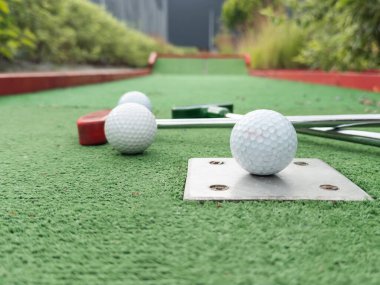 Sentetik çimlerin üzerinde golf topları olan renkli golf sopaları. Yüksek kalite fotoğraf