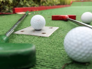 Sentetik çimlerin üzerinde golf topları olan renkli golf sopaları. Yüksek kalite fotoğraf