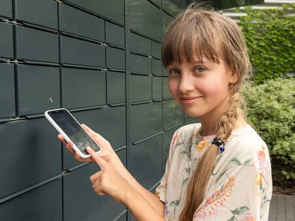 stock image the girl using an automatic self-service terminal . Quarantine delivery, outbreak, covid-19 coronavirus in a pandemic, safety delivery. High quality photo