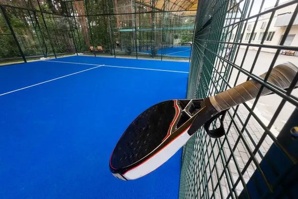 stock image Paddle tennis: Paddel racket and ball in front of an outdoor court. High quality photo