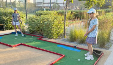  Çocuklar mini golf oynuyor. Çocuk golfçüsü. Yüksek kalite fotoğraf