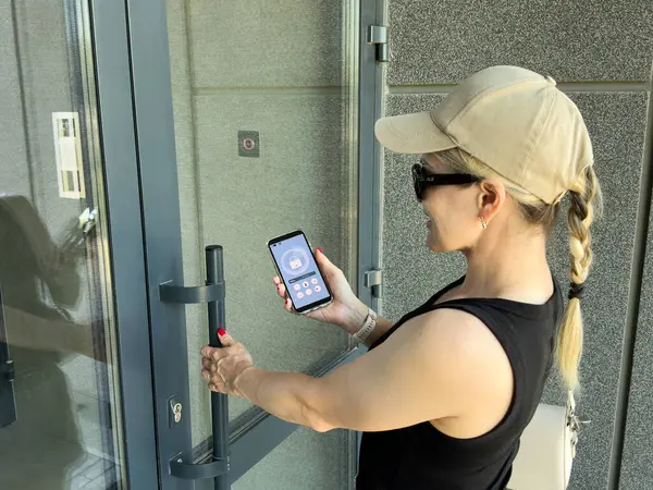 Bina girişinde dahili telefon kullanan bir kadına yaklaş. Yüksek kalite fotoğraf