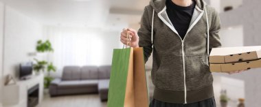 Paket yemek için çeşitli kağıt kaplar. Teslimatçı pizza taşıyor..