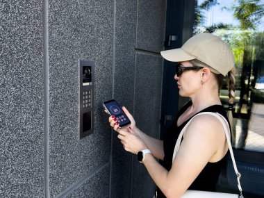 Bina girişinde dahili telefon kullanan bir kadına yaklaş. Yüksek kalite fotoğraf