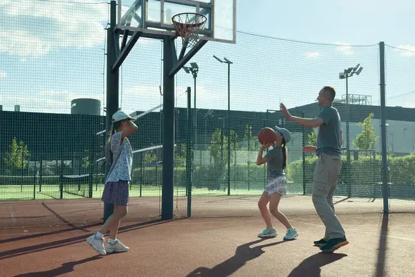 Baba ve genç kızlar sarayda basketbol oynuyorlar. Yüksek kalite fotoğraf