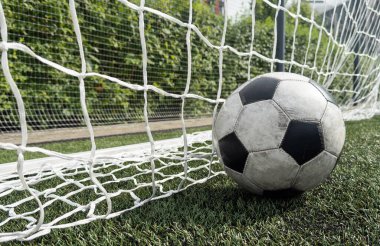 Yeşil çim tarlasıyla gol ağındaki futbol topu. Yüksek kalite fotoğraf