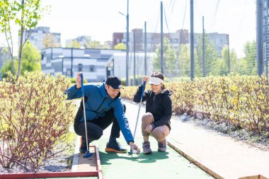 Genç ve yakışıklı bir baba küçük kızına golf oynamayı öğretiyor. Yüksek kalite fotoğraf