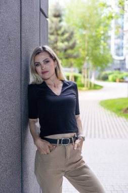 Binanın yanında duran genç, sevimli sarışın. Yüksek kalite fotoğraf