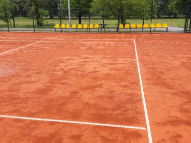 Yağmur yağdıktan sonra ıslanan tenis kortlarının karşısındaki ağlara bakıyorum. Yüksek kalite fotoğraf