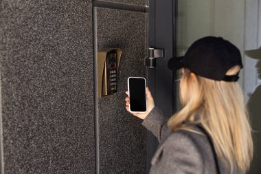 Kadın akıllı telefonla kapıyı açar. Yüksek kalite fotoğraf