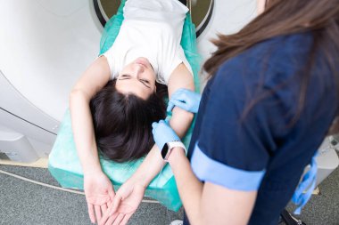 Radyolog, bilgisayarlı tomografi odasında bir kadın hasta ile birlikte.