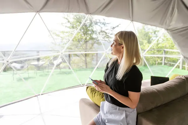 stock image woman with smartphone in geo dome tent.