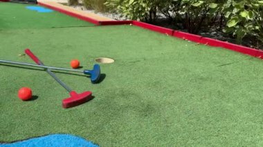 Sentetik çimlerin üzerinde golf topları olan renkli golf sopaları. Yüksek kalite fotoğraf