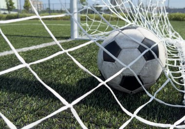 Yeşil çim tarlasıyla gol ağındaki futbol topu. Spor konsepti için. Yüksek kalite fotoğraf