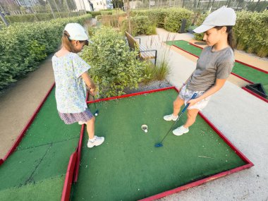 Genç kızlar sahada mini golf oynarlar. - Evet. Yüksek kalite fotoğraf