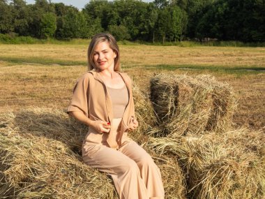 Çekici, samanlığın yanında bej renkli seksi bir sarışın. Yüksek kalite fotoğraf