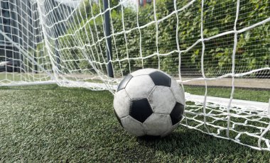 Yeşil çim tarlasıyla gol ağındaki futbol topu. Yüksek kalite fotoğraf