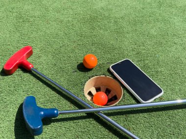Golf sopaları, akıllı telefon ve suni çimlerde taşakları olan seriler. Yüksek kalite fotoğraf