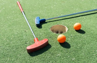 Sentetik çimlerin üzerinde golf topları olan renkli golf sopaları. Yüksek kalite fotoğraf