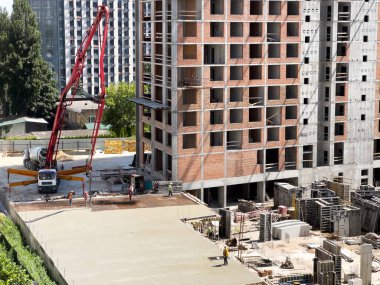 Şehirde güçlendirilmiş beton ve tuğlalardan oluşan çok katlı kompleks binalar inşa ediliyor. Yüksek kalite fotoğraf