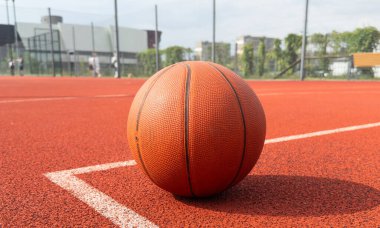 Spor arka planındaki turuncu basketbol topunun güneş ışığıyla aydınlatıldığı yerde fotokopi çekiliyor. Yüksek kalite fotoğraf