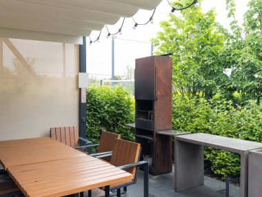 Arka bahçesinde açık hava koltukları ve ailesiyle barbekü. Yüksek kalite fotoğraf