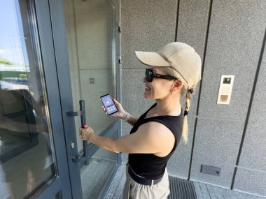 Bina girişinde dahili telefon kullanan bir kadına yaklaş. Yüksek kalite fotoğraf