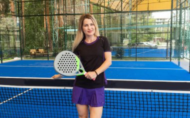 Gün ışığında maç sırasında Padel raketle tenis oynarken gözlerini kaçıran genç bir kızın yan görüntüsü. Yüksek kalite fotoğraf