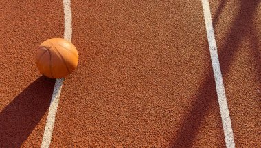 Basketbol topu yere düştü. Kırmızı sahada yakın çekim topu. Sokakta ya da kapalı sahada basketbol. İnsansız spor malzemeleri. Minimalizm. Şablon, spor geçmişi. Yüksek kalite fotoğraf