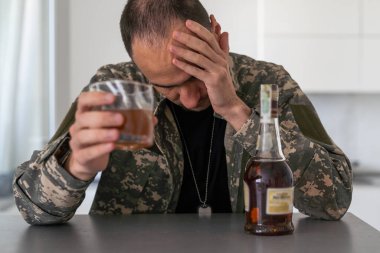 Kamuflajlı bir adam ordudan döndükten sonra depresyona girer. Bodrumda alkol içiyor. Ağır anılar yüzünden acı çekiyor. Yüksek kalite fotoğraf