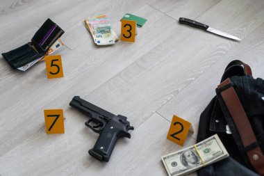 Olay yeri inceleme konsepti, tabanca ve mermi kovanına karşı apartmanın zeminindeki sarı işaret. Yüksek kalite fotoğraf
