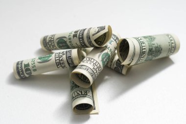 roles dollar notes in front of white background.
