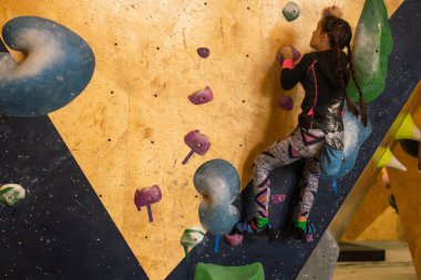 Kapalı spor salonu duvar tırmanma Junior dağcı kız forması asılı tutar.