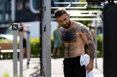 Bir adam egzersiz makineleriyle sokakta antrenman yapıyor..