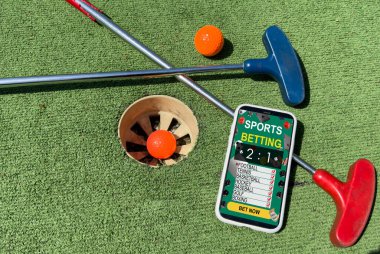 Yeşil çimenlikteki golf aletleri. Akıllı telefondan mini golf bahisleri. Yüksek kalite fotoğraf