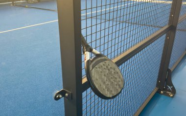 Padel tenis raketi bir padel kortunda tenis topunun yanında yerde yatıyor. Yüksek kalite fotoğraf