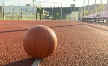 Basketbol topu yere düştü. Kırmızı sahada yakın çekim topu. Sokakta ya da kapalı sahada basketbol. İnsansız spor malzemeleri. Minimalizm. Şablon, spor geçmişi. Yüksek kalite fotoğraf