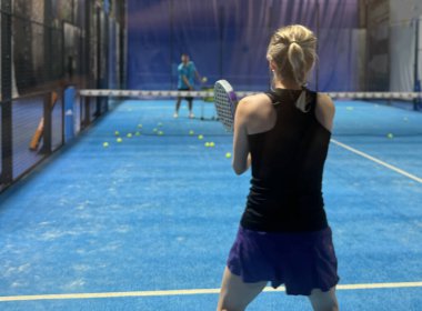 Bir kadın Padel oynuyor, açık mavi bir sahada topa vuruyor. Yüksek kalite fotoğraf