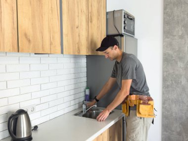 İşçi mutfak lavabosu için musluk kuruyor. Yüksek kalite fotoğraf