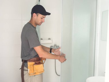 Tesisatçı banyoya duş kabini kuruyor. Yüksek kalite fotoğraf