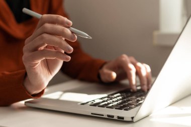 Toplantı raporu devam ediyor. Bilgisayarının klavyesinde elinde kalemle masa başında yazı yazan, modern ofiste geçmişi bulanık çalışan bir iş adamı. Kapatın. İş ve teknoloji kavramı