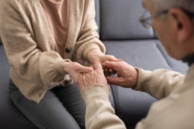 Senior couple, happy and laughing in their home with love, care and support for retirement lifestyle. Commitment of a funny man and woman in a marriage with trust and security on a living room couch