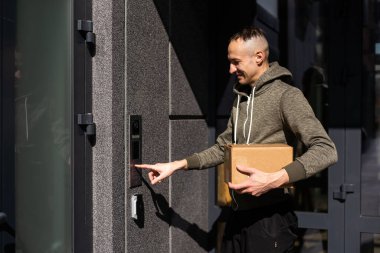 Binanın girişinde kameralı bir adam var.