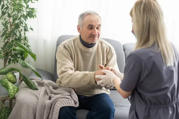 stock image Nurse holding hand of senior man in rest home