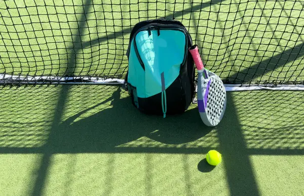 stock image Blue bag with tennis padel racket and ball on grassy field at tennis court, copy space. Unaltered, sport, competition, green, nature and summer concept. High quality photo