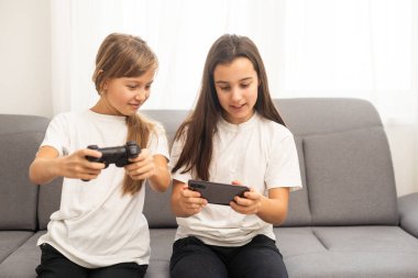 Evde birlikte oyun oynayan iki ortaokul öğrencisi kız. Yüksek kalite fotoğraf